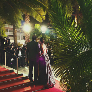 Rani Mukerji and Vishal Jethwa at the Cannes Film Festival, posing on the red carpet with bustling crowds and flashing cameras.