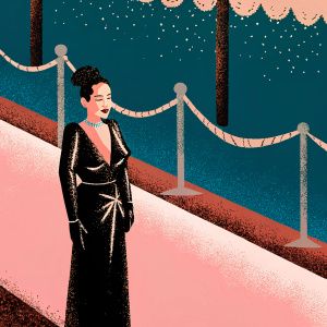 Archie Panjabi at an awards show, pink carpet with sponsors' logos. Wearing a black leather gown, hair styled up, looks radiant and confident.
