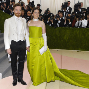Michael Fassbender and Catherine Fassbender attending the Met Gala. Lavish red carpet surrounded by paparazzi and celebrities.