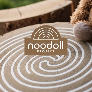 Digital illustration of Noodoll Project logo. Modern, graphic design featuring spiral pattern. Text reads 'Noodoll Project'. Neutral tones with blurred, brownish texture background.