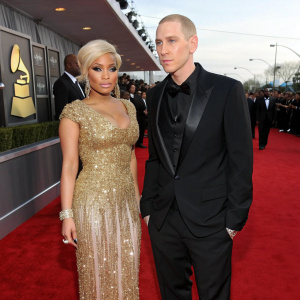 Nicki Minaj and Eminem at the Grammy Awards, both dressed in formal attire. Nicki in a gold sequined dress, Eminem in a black tuxedo.