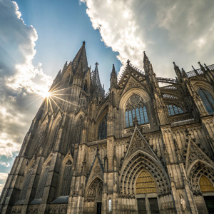 Imposing facade of the Cologne Cathedral, Germany. Exterior view, sunlit sky, with intricate stonework. Gothic architecture, tall spires reaching towards the clouds.