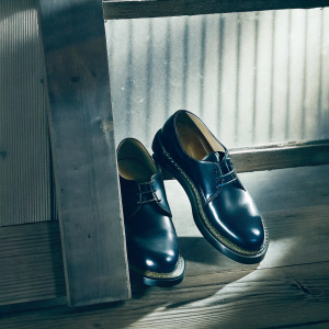 Classic black Dr Martens 1461 dress shoes, featuring a smooth leather upper and durable rubber sole. Shiny, elegant appearance.