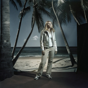 Mikaela Shiffrin, the renowned skier, on a vibrant tropical beach. Surrounded by palm trees and clear blue ocean.