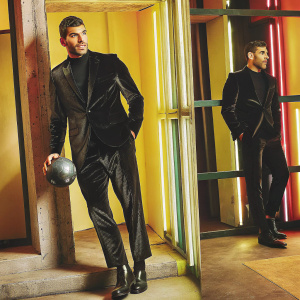 Theo Hernandez, soccer player, in sleek black suit. Professional photoshoot in vibrant studio setting.