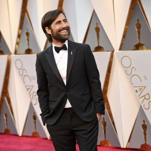 Jason Schwartzman at the Oscars. Wearing a black tuxedo and a big smile.