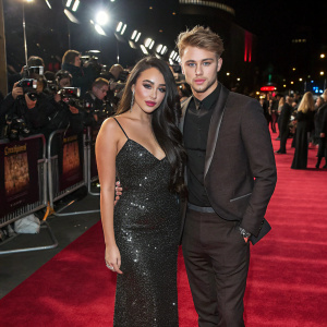 Marnie Simpson and Casey Johnson attending a glitzy Hollywood premiere. Lavish red carpet surrounded by flashing cameras and paparazzi.