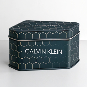 Conceptual packaging design for Calvin Klein. Dark hexagonal pattern. Modern industrial style. Product branding prominently featured.