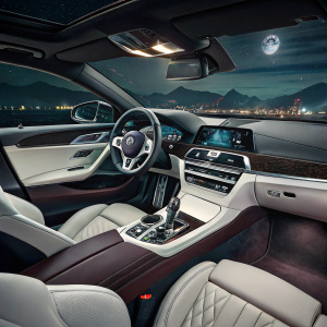 Luxurious interior of a BMW M8 Gran Coupe. Dark leather seats, sleek white and black dashboard with metallic trim.