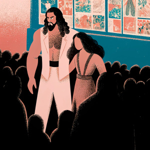 Jason Momoa and Lisa Bonet at a comic con event. Crowd of fans around them. Vibrant poster stand in the background.