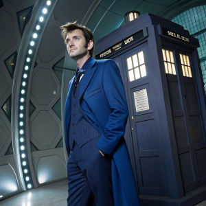 David Tennant, wearing the iconic TARDIS blue suit from Doctor Who, standing in a futuristic set.