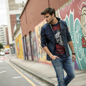 Ethan, wearing Gian Carlo Rossi's latest casual collection. Stylish jeans and a graphic tee. Urban street scene, bold graffiti background.