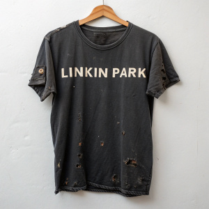 A close-up image of a worn-out black Linkin Park t-shirt. White background, all capital letters in bold font.