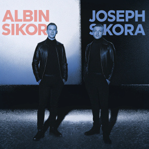 Albin Sikora and Joseph Sikora, both in black turtleneck shirts and leather jackets, posing in a sleek, modern studio. The background features bold, graphic-style text in muted colors.