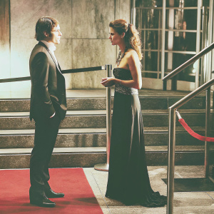Stuart Townsend and Hannah Ware in intense conversation at an awards ceremony. Red carpet backdrop