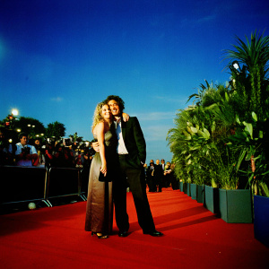 Jason Momoa and a blonde woman at the New York Film Festival. They are embracing and smiling. Red carpet event