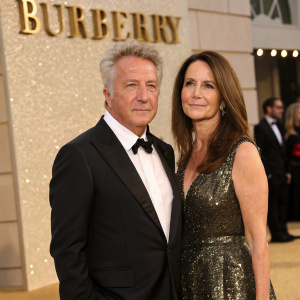 Dustin Hoffman and Alexandra Hoffman at a glitzy gala. They stand in front of a luxurious Burberry backdrop.