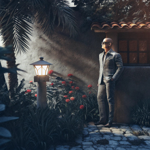 Jeff Bezos, Amazon's visionary founder, poses outdoors in a vibrant garden setting. He stands near a quaint fire hydrant, his face partially obscured by sunglasses.