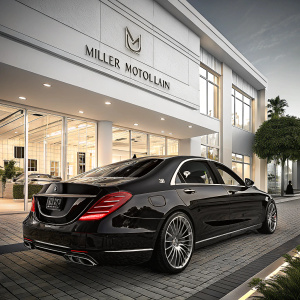 A glossy picture of a black Mercedes-Benz S63 parked outside a luxury car dealership. Miller Motorcars nameplate visible. The car features chrome trim and sleek tail lights. The background showcases a modern, white-walled showroom with ample lighting.