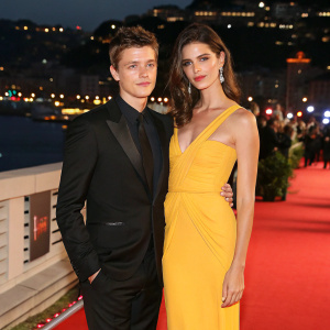 Xavier Samuel and Shermine Shahrivar at the film festival premiere. City lights backdrop, black suit and yellow dress