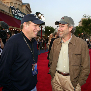 Michael Eisner and Steven Spielberg at a premiere event. Disney Studios merchandise, casual attire, outdoor setting