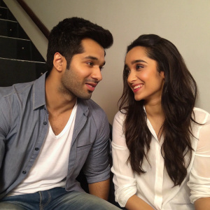 Varun Dhawan and Shraddha Kapoor in a candid photo. Both are promoting their film ABCD 2. Varun in casual shirt, Shraddha in white shirt. They are sitting close together.