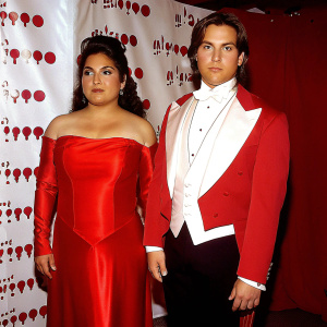 Gabriella Lopez and James Maslow at the GLAAD Media Awards. Formally dressed. White backdrop with GLAAD logo