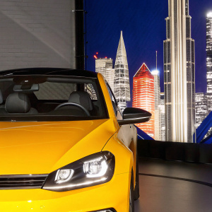 A sleek Volkswagen car parked in a futuristic cityscape. The vehicle's distinctive VW logo and angles highlighted. Automotive photography.