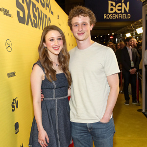 Taissa Farmiga and Ben Rosenfield attending a film festival. They both wear casual outfits. Vibrant yellow backdrop with sponsors' logos.