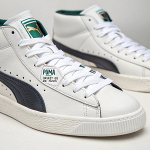 Close-up image of Puma Basket '68 Mid Trainers. White laces and clean design. Brand logo on the side. Plain background.
