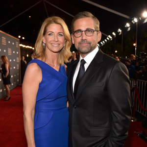 Steve Carell and Nancy Carell posing at the annual Critics' Choice Awards. Steve in a sleek black suit, Nancy in a striking blue dress. Red carpet and lights, crowd visible in background.