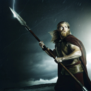 Odin, the one-eyed Norse god, in a fierce battle stance, wielding his mighty Gungnir spear. Dark, ethereal backdrop, stormy clouds swirl around him.