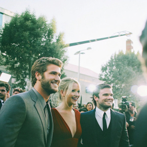 Liam Hemsworth, Jennifer Lawrence, and Josh Hutcherson at the premiere event for The Hunger Games: Mockingjay - Part 2. Red carpet setting.