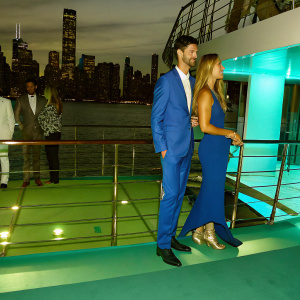 Novak Djokovic and Filippa Lagerback at a luxury yacht party. City skyline backdrop.