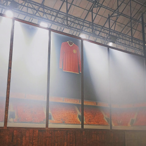 Photograph of Marcus Rashford's Manchester United jersey. Displayed in sports hall of fame, lit with spotlights. Dark backdrop