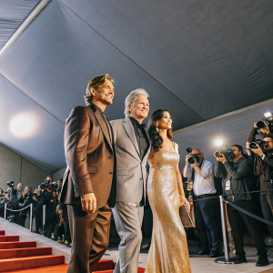 Michael Douglas, Dylan Michael Douglas, and Catherine Zeta-Jones at the premiere of Ant-Man and The Wasp: Quantumania. Bright lights, red carpet, paparazzi flashing