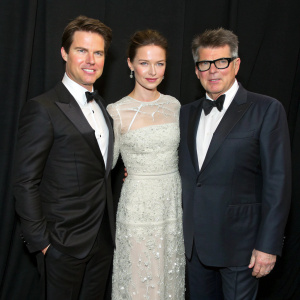 Tom Cruise, Rebecca Ferguson, and Christopher McQuarrie at the awards show. Black background