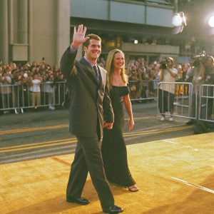 Chris O'Donnell and Caroline Fentress attending the Hollywood premiere of 'Batman Forever'. Glimmering red carpet. A sea of photographers and fans.