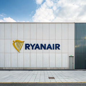Ryanair's logo prominently displayed on sleek, modern facade. Stylized harp in vivid yellow, bold blue text, minimalist backdrop.
