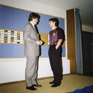Robert Lewandowski and Joan Laporta at Barcelona FC press conference. They stand in front of a blue backdrop with sponsor logos. The setting is formal and professional.