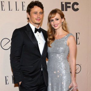 James Franco and Ahna O'Reilly at a chic red carpet event. Franco is dressed in a sleek black tuxedo. O'Reilly is resplendent in a sparkling silver gown. The backdrop showcases the logos of Elle and IFC.