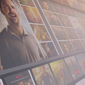 Homepage of Netflix featuring various TV shows and movies. Dynamic grid layout with dark theme. Actor close-up in front of promotional banner
