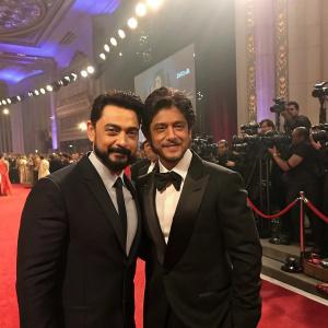 Aamir Khan and Shah Rukh Khan, in formal suits, attending a high-profile awards ceremony.