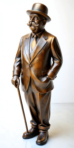 A bronze statue of Hercule Poirot as played by David Suchet, a bowler hat on his head, fine mustache, with a walking cane, left hand placed behind back