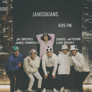 The Janoskians, Jai Brooks, Daniel Sahyounie, James Yammouni, Luke Brooks, and Beau Brooks, posing in front of a neon-lit cityscape. Each member is dressed in a different color outfit, complemented with quirky hats. The backdrop features vibrant KIIS FM logos.