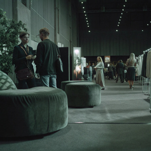 Modern exhibit booth for Archer. Sleek, green-themed design with ambient lighting. Crowded event space.