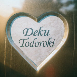Heart-shaped graphic featuring the names 'Deku' and 'Todoroki' from the series 'My Hero Academia'. Set against a gradient background.