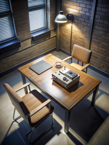 The police interrogation table in the old days, there are files on the table and a tape recorder... we see the picture from a high angle.