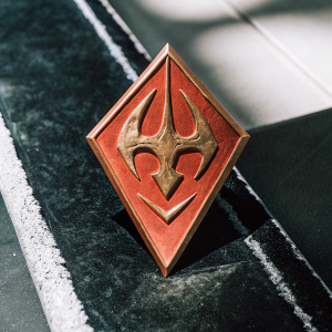 A glossy golden emblem with intricate details, featuring the Spyro logo. Set against a stark black backdrop, this is a high-quality 3D render.