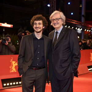 Davide Giordano and Vittorio Sgarbi attending the Berlinale film festival. Curly hair, dark shirt for Giordano. Sgarbi in a tailored suit.